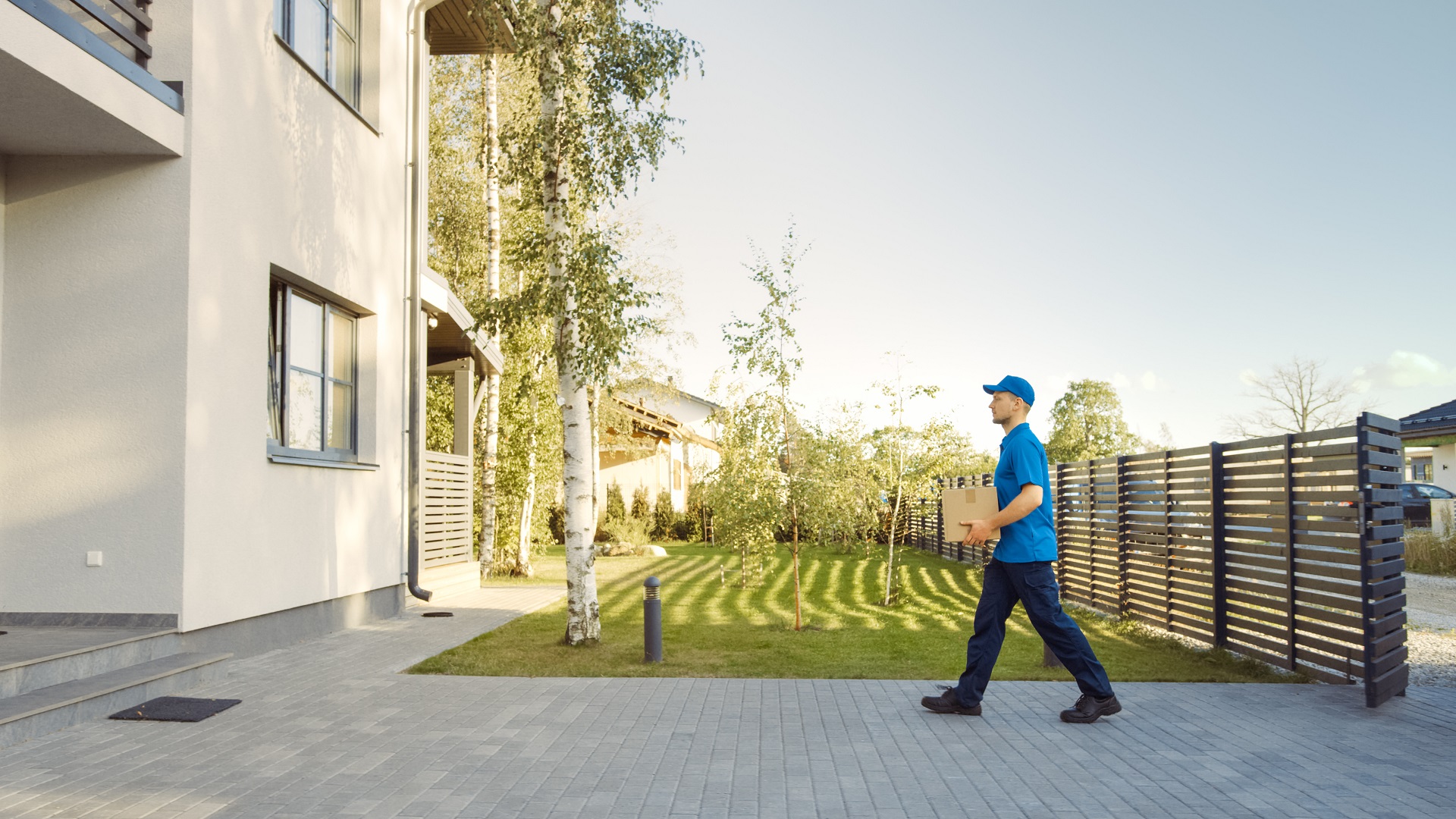 Delivery,Man,Holding,Card,Board,Package,Enters,Through,The,Gates